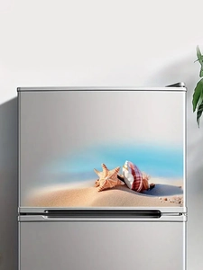 Detail of adhesive shell and starfish sticker on silver refrigerator door surface