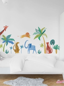 Détail de stickers muraux avec animaux au crayon et palmiers sur un mur de chambre blanc