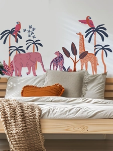 Détail du sticker mural avec éléphant rose et girafe dans une chambre d'enfant
