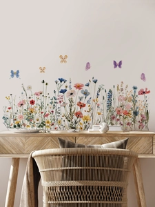 Détail de stickers muraux fleurs sauvages aquarelle et papillons sur un mur blanc