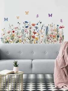 Détail de stickers muraux aquarelle avec fleurs sauvages et papillons sur mur blanc