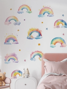 Close-up of watercolor rainbow and star wall decals on a clean white nursery wall