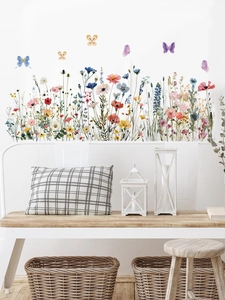 Détail de stickers muraux floraux avec fleurs sauvages et papillons sur un mur blanc