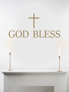 Detailed view of God Bless wall decal with cross symbol above a modern white fireplace
