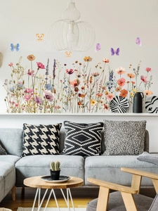 Détail de stickers muraux avec des fleurs sauvages colorées et des papillons sur fond blanc