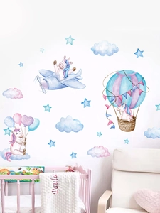 Detail showing watercolor unicorn wall stickers with stars and clouds in a nursery room