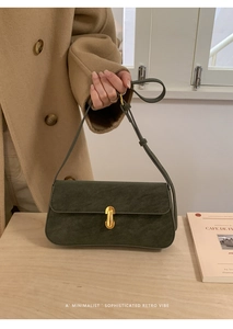 Détail d'un sac bandoulière en PU vert foncé avec fermoir métallique doré en forme de U