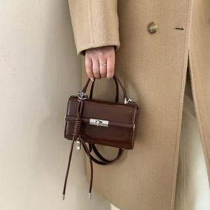 Detail of dark brown litchi pattern PU leather strap with silver metal D-ring buckle