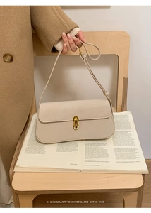 Détail d'un sac à bandoulière crème avec fermoir en métal doré et bandoulière fine