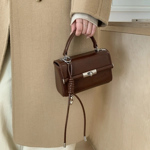 Detail of dark brown lychee texture PU leather shoulder strap with silver metal swivel D-ring clasp