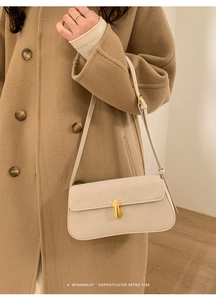 Détail d'un sac à bandoulière minimaliste en cuir PU crème avec boucle dorée et sangle réglable