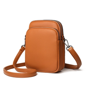 Orange lychee leather crossbody bag with three zipper layers and adjustable strap