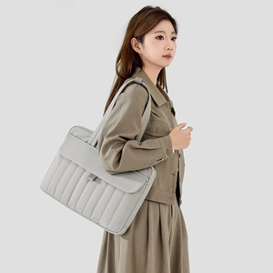 Vista dettagliata di una borsa porta pc trapuntata grigio chiaro con tracolla