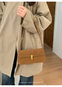 Sac porté épaule rétro minimaliste marron caramel avec boucle dorée assorti à un trench-coat kaki