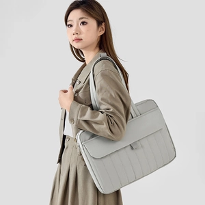 Borsa porta PC grigio chiaro minimalista mostrata con abbigliamento formale su modella