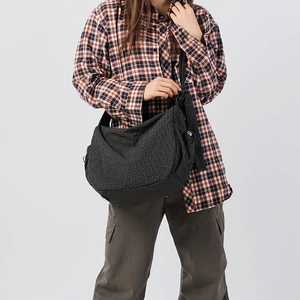 Vista dettagliata della borsa a tracolla a quadretti grigio scuro con look casual