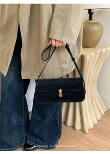 Détail d'un sac à bandoulière vintage en cuir PU noir avec boucle dorée en forme de U
