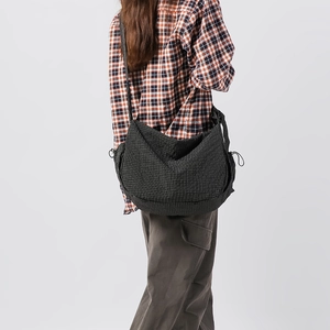 Dettaglio della borsa hobo in nylon grigio a scacchi con coulisse e design spazioso