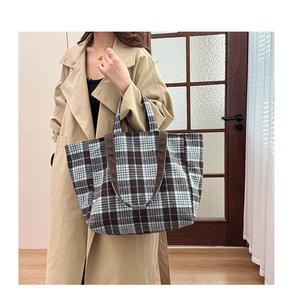 Sac cabas en laine à carreaux style anglais avec trench-coat kaki dans un décor cosy