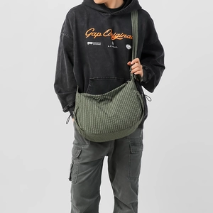 Dettaglio della borsa hobo in nylon a quadri verdi con tracolla larga e grande design