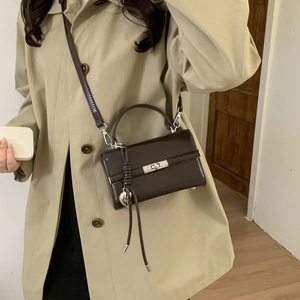 Detail of adjustable chocolate brown PU leather bag strap with silver metal buckle