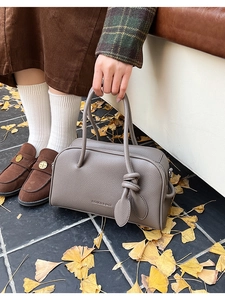 Detail der grauen Boston-Tasche aus Leder mit Blattknoten-Dekor im herbstlichen Freien