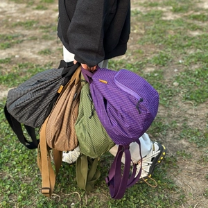 Photo en extérieur de quatre sacs bandoulière légers en nylon quadrillé de diverses couleurs