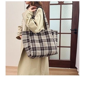 Grand sac cabas à carreaux porté par un mannequin montrant les détails de texture en laine
