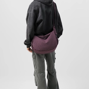 Macro di borsa hobo in nylon a quadretti viola scuro indossata da un modello in stile casual