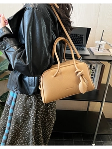 Detail der kamelfarbenen Boston-Tasche mit Litschimuster und dekorativem Knotengriff