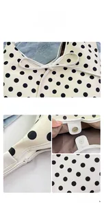 Detail view of cream nylon bag with black polka dots featuring magnetic clasp and bow knot