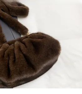 Détail du sac en fausse fourrure marron foncé avec texture plissée et boucle dorée