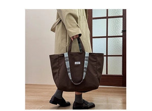 Détail du sac cabas marron foncé avec anses à carreaux noir et blanc et étiquette mode