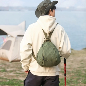 Détail d'un mini sac à dos tactique en nylon quadrillé vert armée en décor de camping