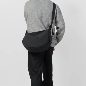 Borsa a mezzaluna in nylon nero minimalista indossata a tracolla con grande capacità