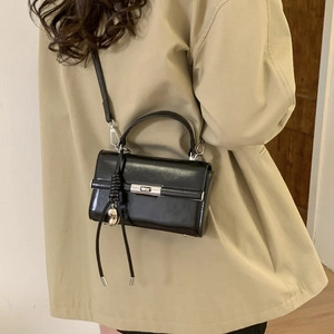 Detail of adjustable PU leather shoulder strap with silver D-ring buckle and swivel hook