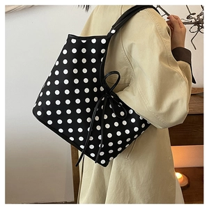 Close-up of stylish polka dot tote bag with elegant side ribbon bow tie detail