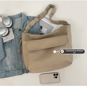 Flat lay of khaki nylon tote bag showing spacious capacity and pleated strap detail