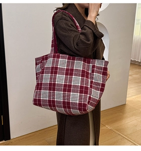 Gros plan du sac cabas à carreaux rouge et blanc montrant la texture douce du tricot
