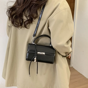 Close-up of adjustable black litchi PU leather shoulder strap with silver D-ring metal buckle
