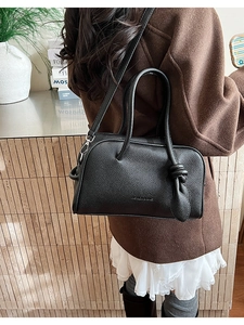 Detail der schwarzen Boston-Tasche aus strukturiertem Leder mit geknotetem Griff