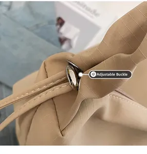 Close-up of the silver metal toggle and durable nylon texture of the beige tote bag