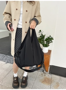 Detailaufnahme einer schwarzen Nylon-Einkaufstasche mit verstellbaren Trägern und Multi-Taschen
