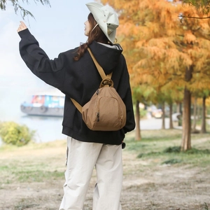 Petit sac à dos à carreaux marron dans un décor d'automne avec bretelles ajustables