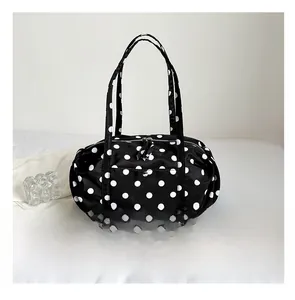 Comparaison détaillée de la taille du grand sac à pois à côté d'un smartphone bleu