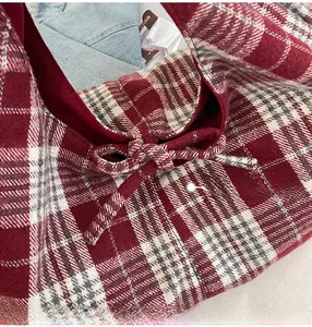 Detail of red and white plaid tote bag with bow tie and textured fabric
