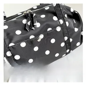 Vue détaillée du sac de voyage à pois noirs avec des accessoires en métal argenté de qualité