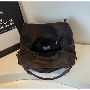 Detail of deep brown tote bag interior with magnetic snap closure and internal zip pocket