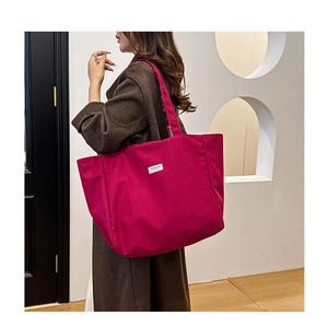Détail d'un grand cabas rose en toile avec étiquette FASHION et sangle à carreaux