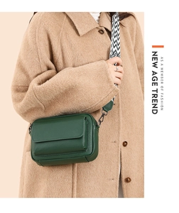 Detalle del bolso bandolera de cuero verde oscuro con correa de jacquard geométrico